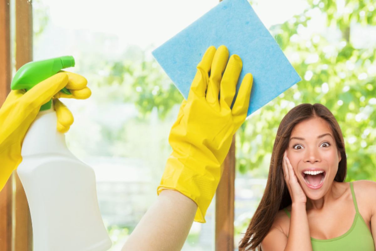 Mano che pulisce un vetro e donna sorpresa in primo piano