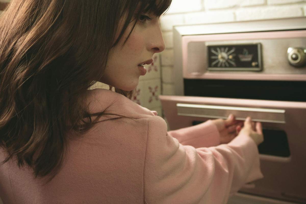Una ragazza che apre un forno